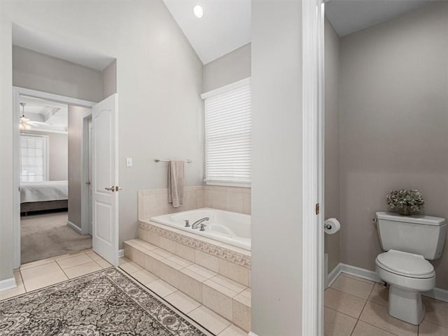 bathroom with tile patterned floors, toilet, and tiled bath