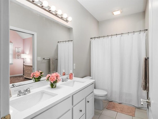 bathroom with toilet, vanity, tile patterned floors, and walk in shower