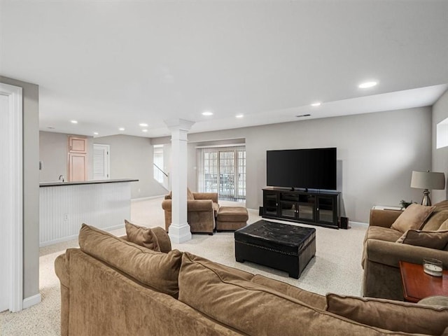 living room featuring decorative columns and light carpet