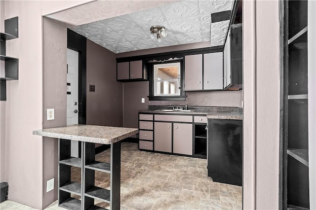 kitchen featuring an ornate ceiling, open shelves, tasteful backsplash, stone finish floor, and a sink