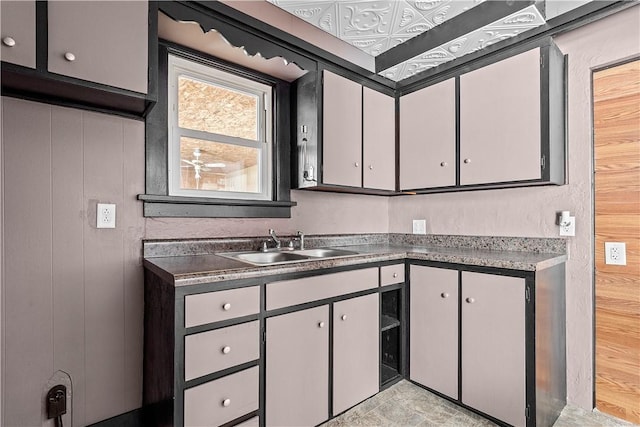 kitchen featuring dark countertops, gray cabinets, and a sink