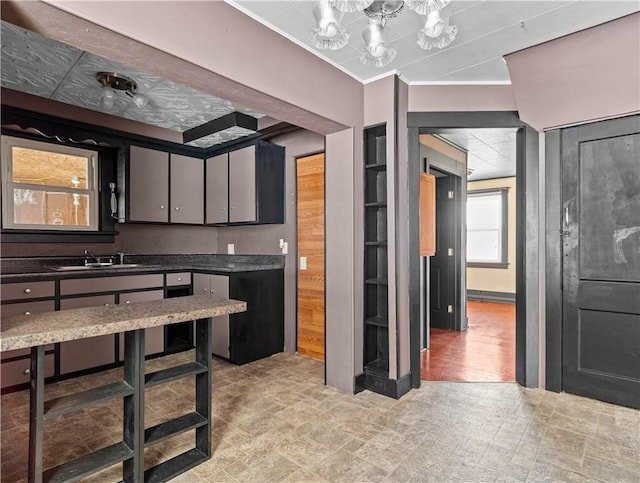 kitchen with ornamental molding, dark countertops, and a sink