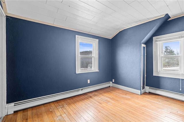 empty room with light wood-type flooring, a healthy amount of sunlight, lofted ceiling, and baseboard heating