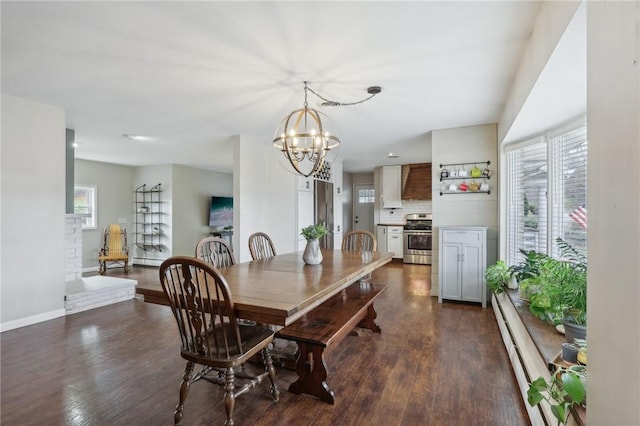 dining space featuring dark hardwood / wood-style flooring, baseboard heating, and an inviting chandelier