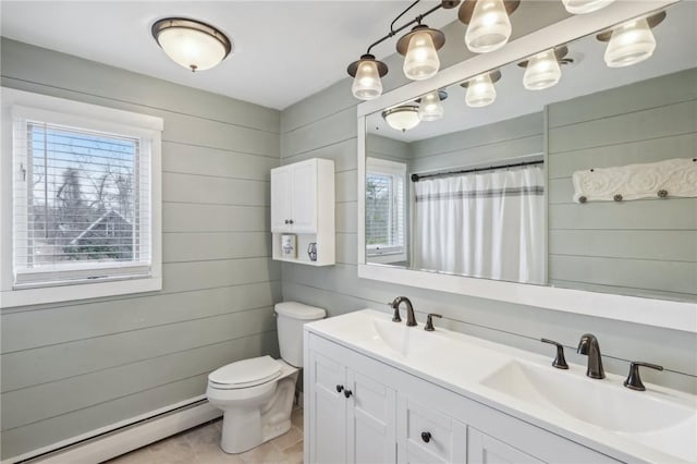 bathroom featuring tile patterned floors, vanity, baseboard heating, toilet, and wood walls