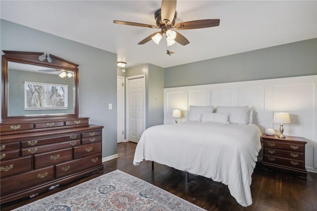 bedroom featuring dark hardwood / wood-style flooring, ceiling fan, and a closet