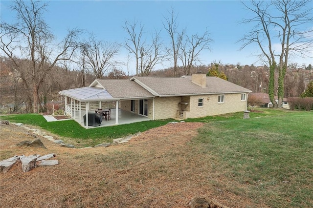 back of property featuring a lawn and a patio area