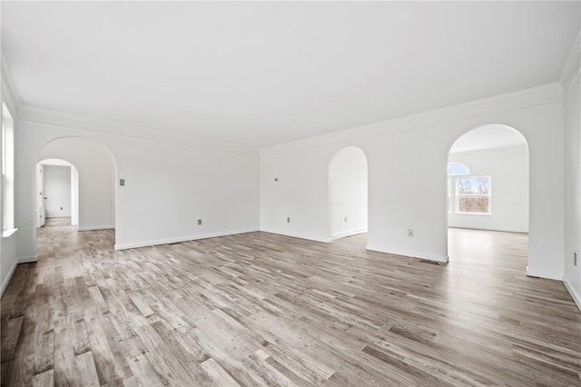 spare room with crown molding and light hardwood / wood-style floors