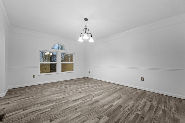 unfurnished dining area with crown molding, wood-type flooring, and a notable chandelier