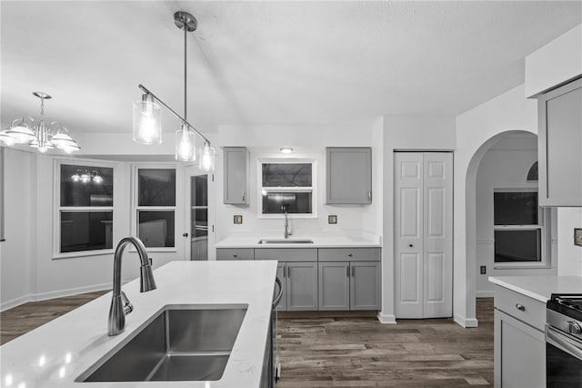 kitchen featuring gray cabinets, sink, dark hardwood / wood-style floors, and decorative light fixtures