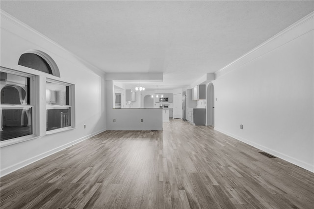 unfurnished living room featuring hardwood / wood-style flooring, a notable chandelier, and a textured ceiling