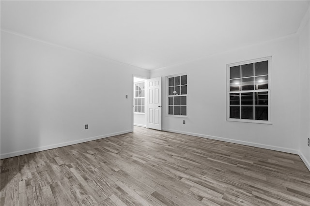 spare room with ornamental molding and wood-type flooring