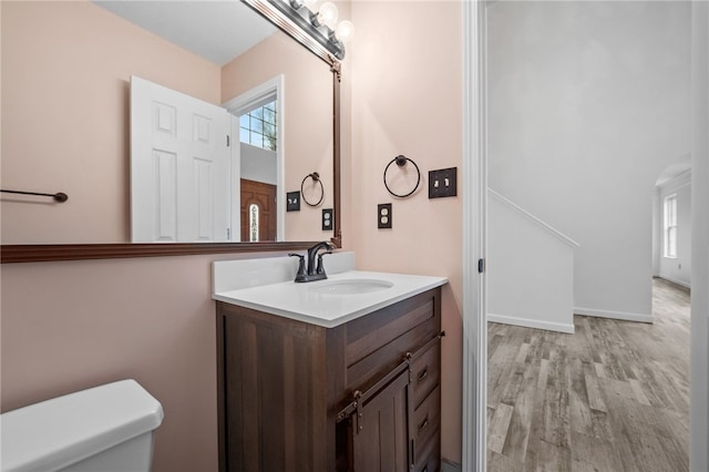 bathroom with hardwood / wood-style flooring, vanity, and toilet