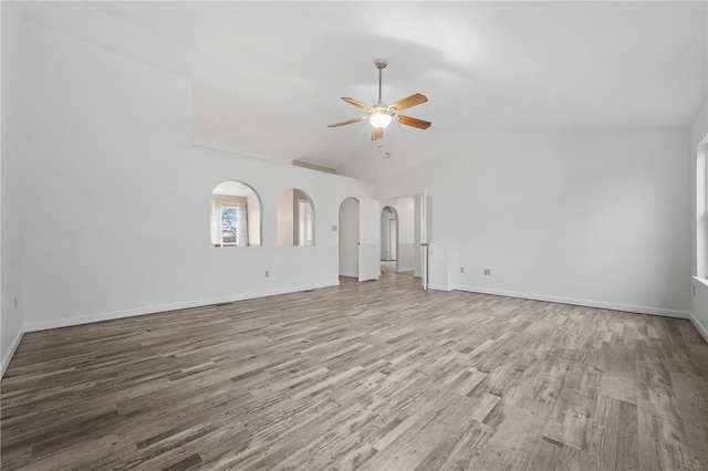 unfurnished living room with ceiling fan, lofted ceiling, and light wood-type flooring