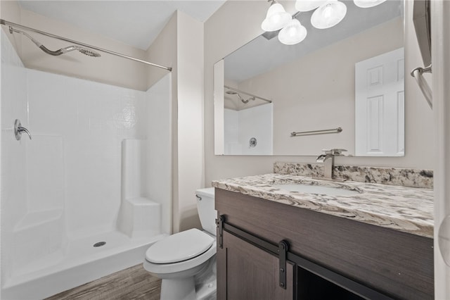 bathroom with vanity, hardwood / wood-style flooring, a shower, and toilet