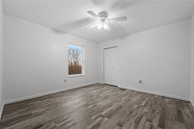 empty room with dark hardwood / wood-style floors and ceiling fan