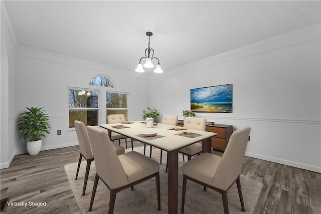 dining room with an inviting chandelier, ornamental molding, and dark hardwood / wood-style flooring