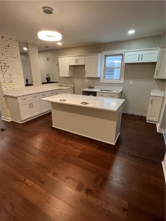 kitchen featuring a center island, decorative light fixtures, white cabinetry, and dark hardwood / wood-style floors