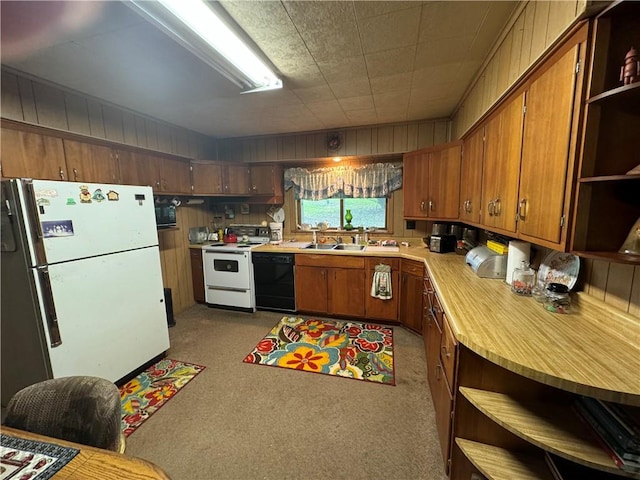 kitchen with black appliances, light carpet, and wooden walls