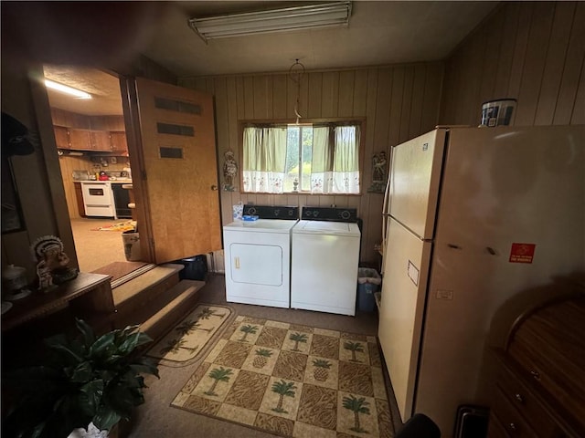 clothes washing area featuring wooden walls and independent washer and dryer