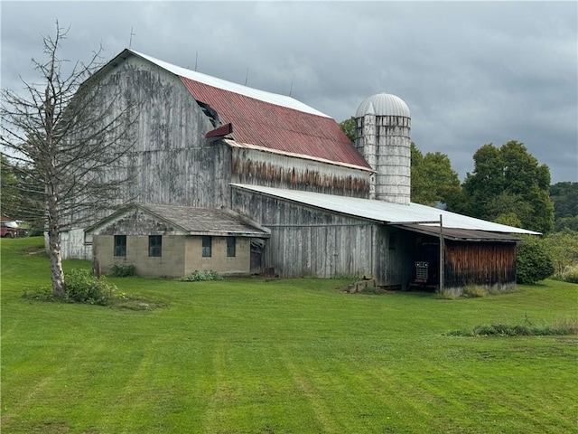 back of house with an outbuilding and a lawn