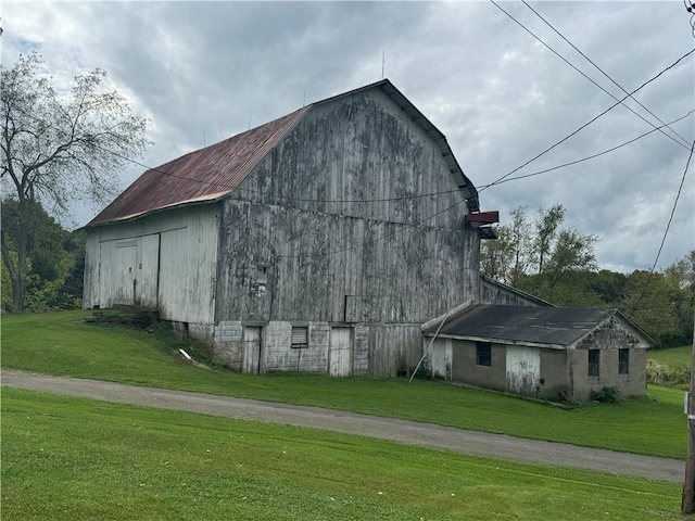 view of property exterior with a lawn and an outdoor structure