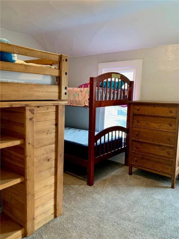 carpeted bedroom featuring vaulted ceiling