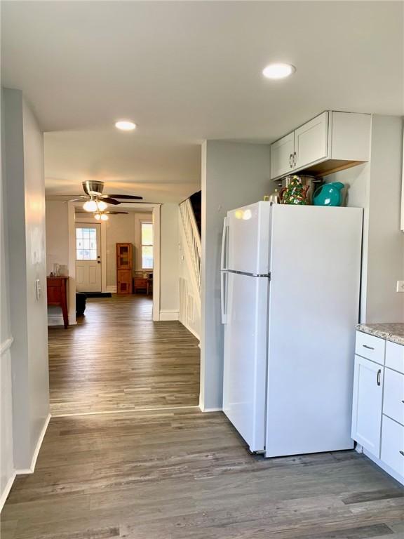 kitchen featuring ceiling fan, white cabinetry, white fridge, and hardwood / wood-style flooring