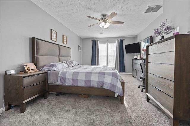 bedroom with ceiling fan, light colored carpet, and a textured ceiling