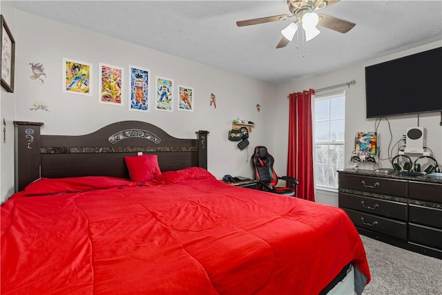 carpeted bedroom featuring ceiling fan and a textured ceiling