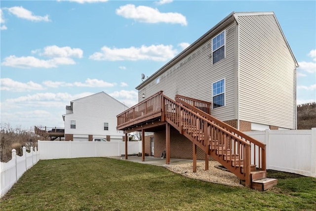 rear view of property with a deck, a patio area, and a lawn