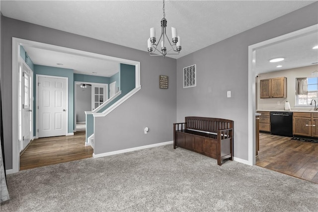 interior space with dark colored carpet, ceiling fan with notable chandelier, and sink