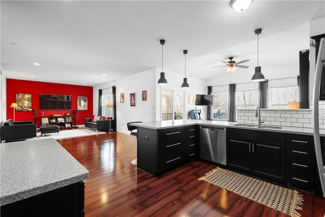 kitchen featuring sink, hanging light fixtures, stainless steel dishwasher, decorative backsplash, and kitchen peninsula