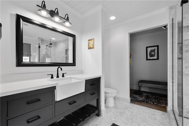 bathroom with tiled shower, vanity, toilet, and ornamental molding