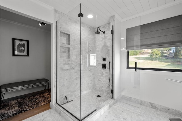 bathroom featuring crown molding and a shower with shower door