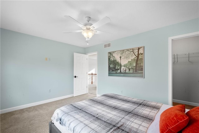 carpeted bedroom featuring ceiling fan, a spacious closet, and a closet