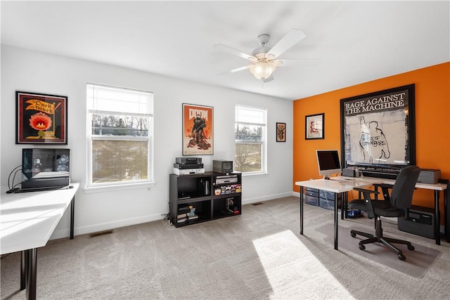 carpeted home office featuring ceiling fan