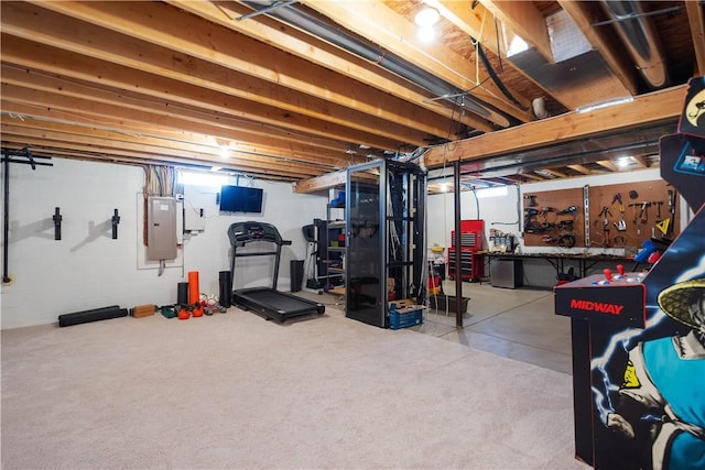 workout room with a workshop area and electric panel