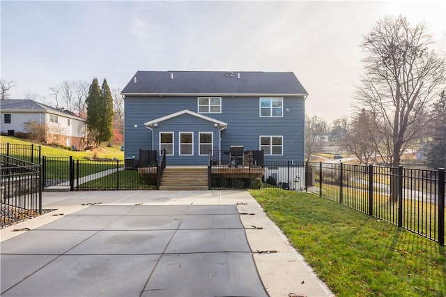 rear view of house with a lawn and a wooden deck