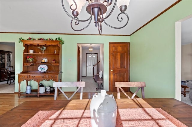 dining space with a chandelier, wood-type flooring, and ornamental molding