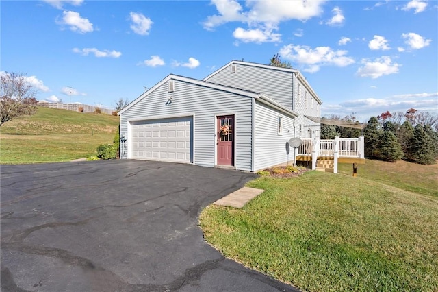 view of front of house featuring a front yard, a garage, and a wooden deck