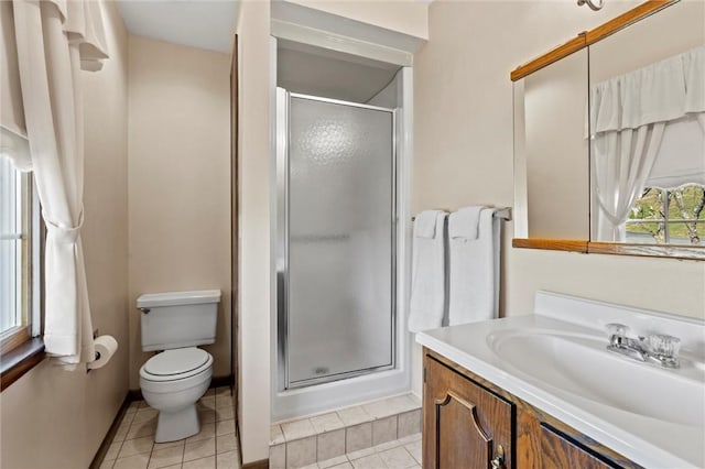 bathroom with tile patterned flooring, vanity, toilet, and walk in shower