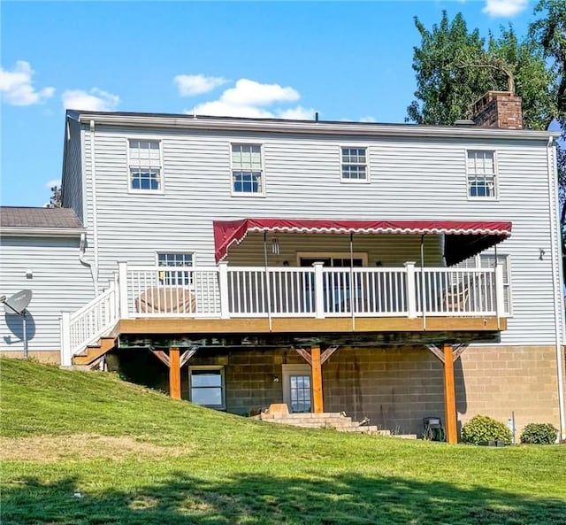 rear view of house featuring a yard and a deck