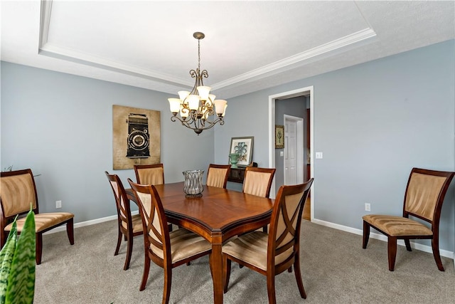 carpeted dining space featuring a raised ceiling and a chandelier