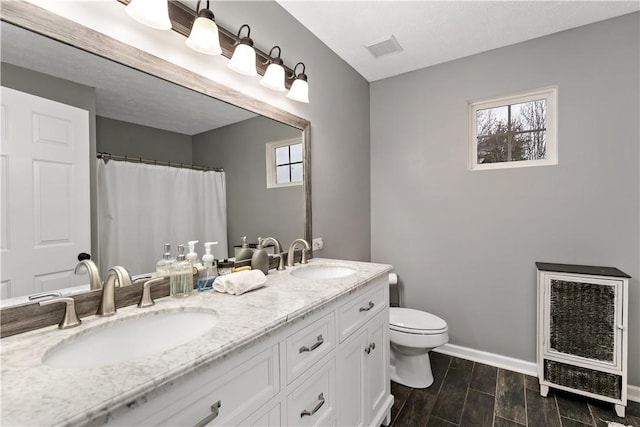 bathroom featuring heating unit, vanity, and toilet