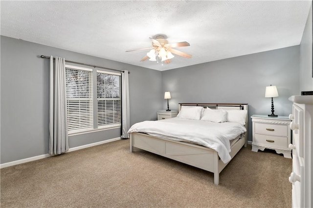 carpeted bedroom with ceiling fan and a textured ceiling