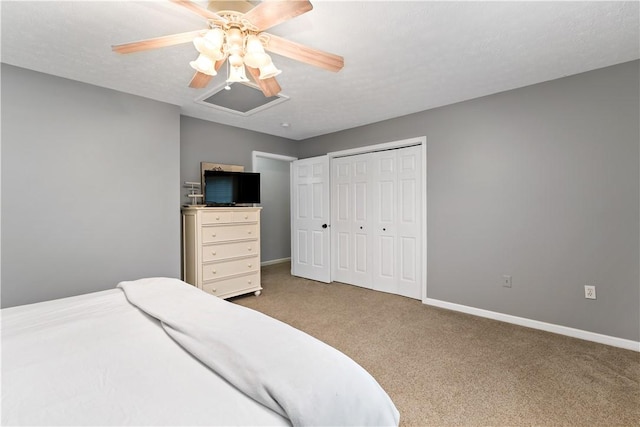 bedroom with a textured ceiling, light colored carpet, a closet, and ceiling fan