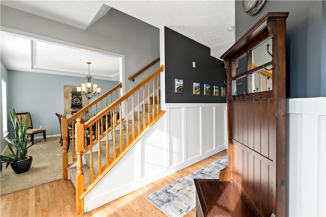 stairway featuring hardwood / wood-style flooring and an inviting chandelier