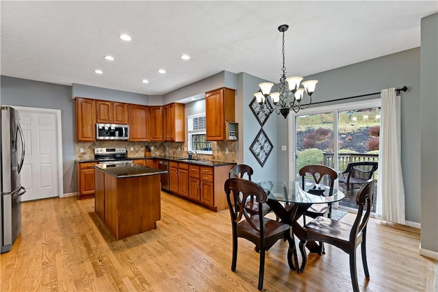 kitchen featuring a center island, sink, stainless steel appliances, an inviting chandelier, and pendant lighting