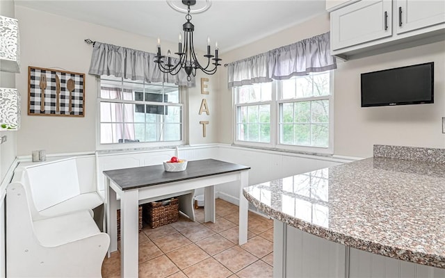 tiled dining space with a chandelier